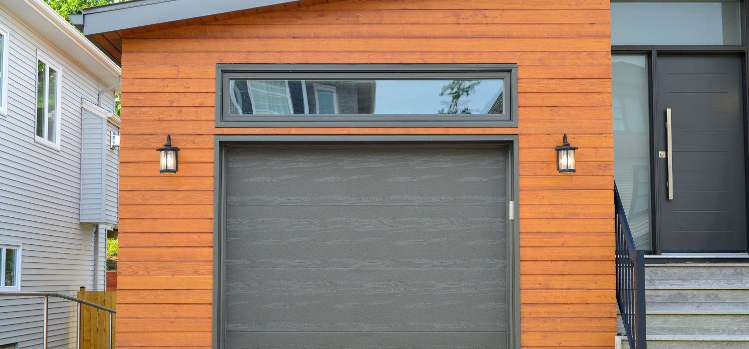 Modern residential garage door with a wood-style exterior and metal frame, showing a contemporary home design suitable for humid climates.